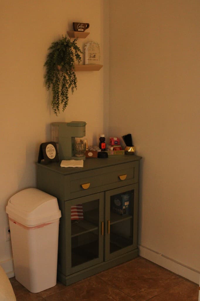 Sage green coffee bar with gold hardware and floating shelves