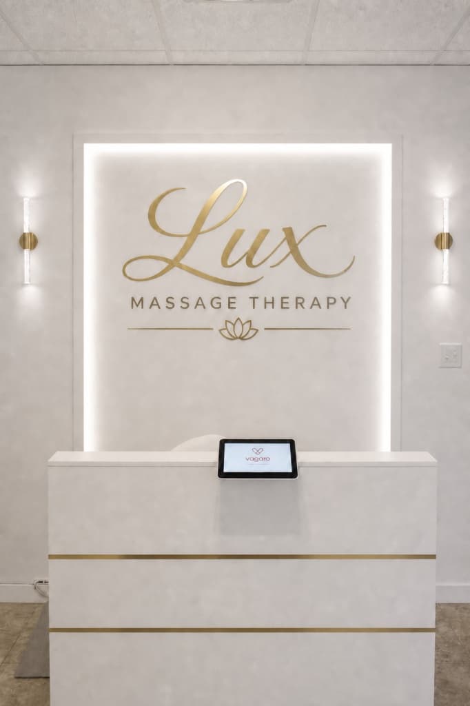 Reception desk with backlit logo and Vagaro booking tablet