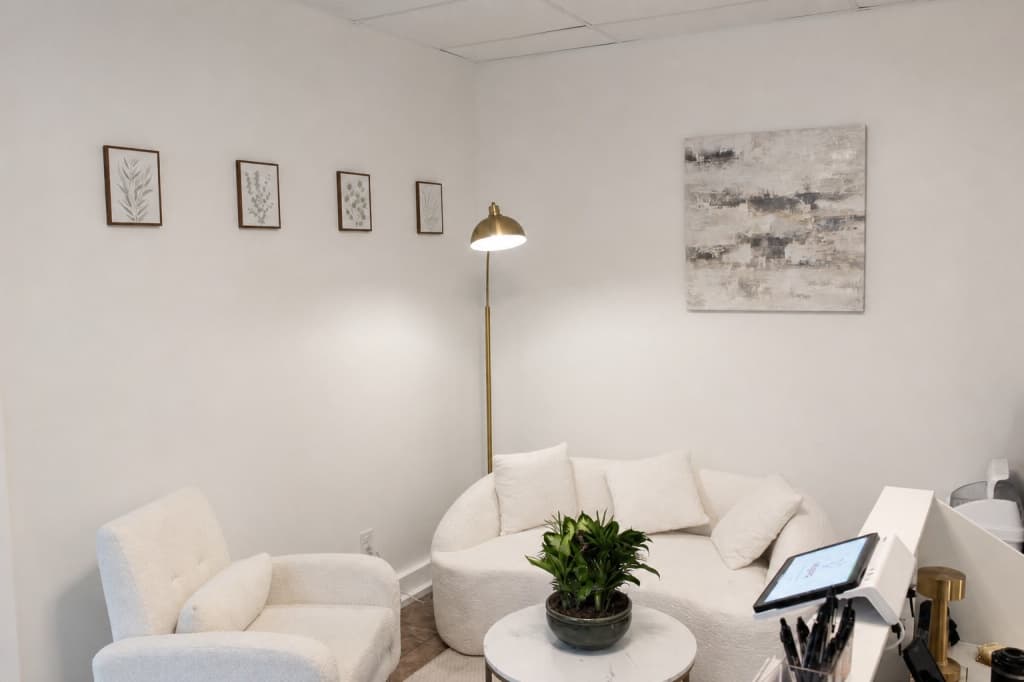 Waiting area with cream seating and a gold floor lamp